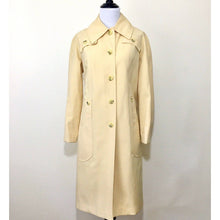 Load image into Gallery viewer, Classic light yellow poly button-down trench coat in excellent condition 
